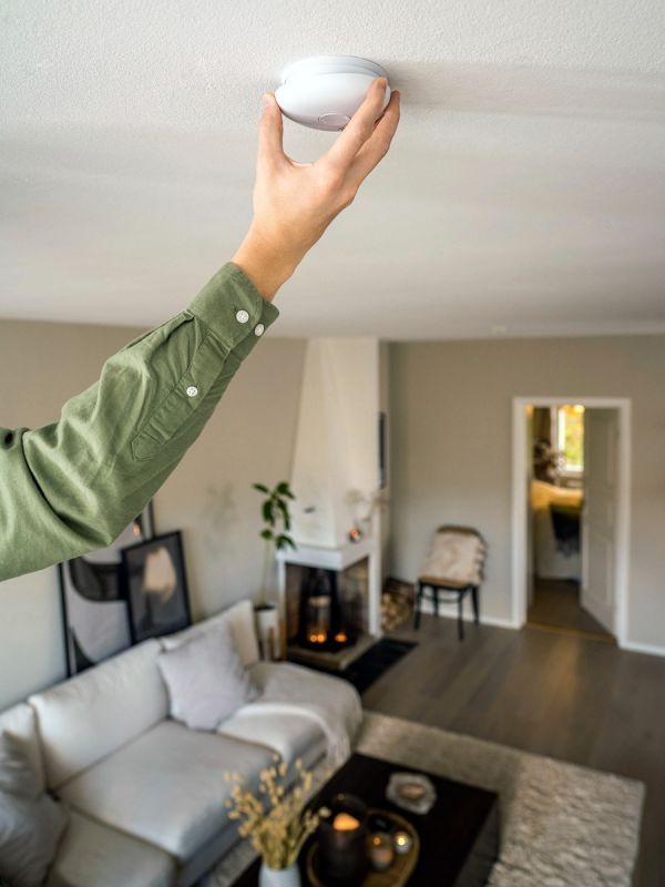 r&oslash;ykvarsler hvit pebble 10 montert i tak i stue med h&aring;nd